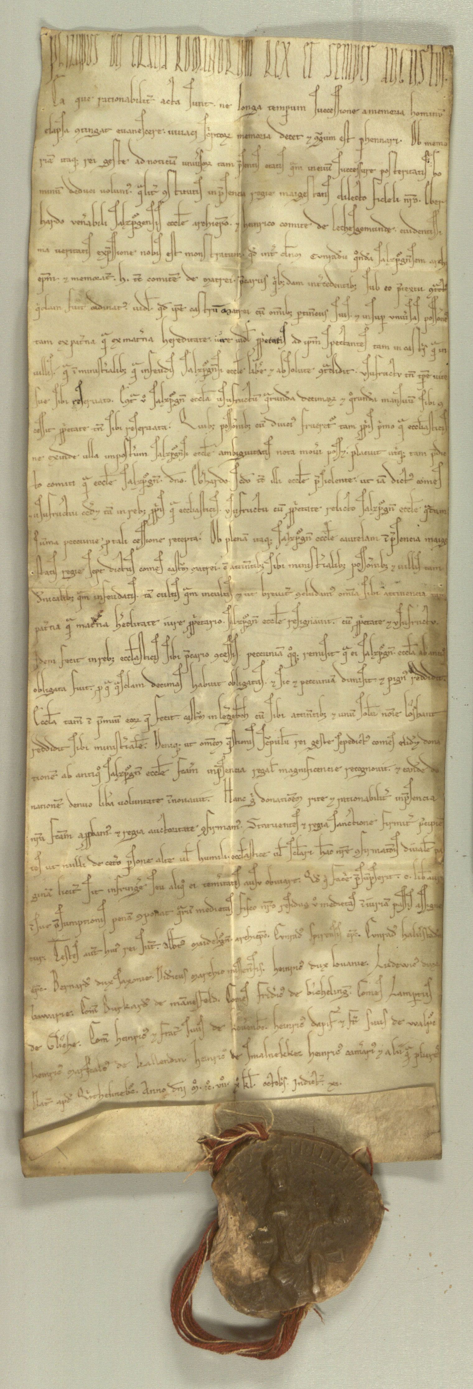 Ein mittelalterliches Manuskript in lateinischer Sprache mit kunstvoller Handschrift, an dessen Unterseite ein Wachssiegel mit einer Schnur befestigt ist