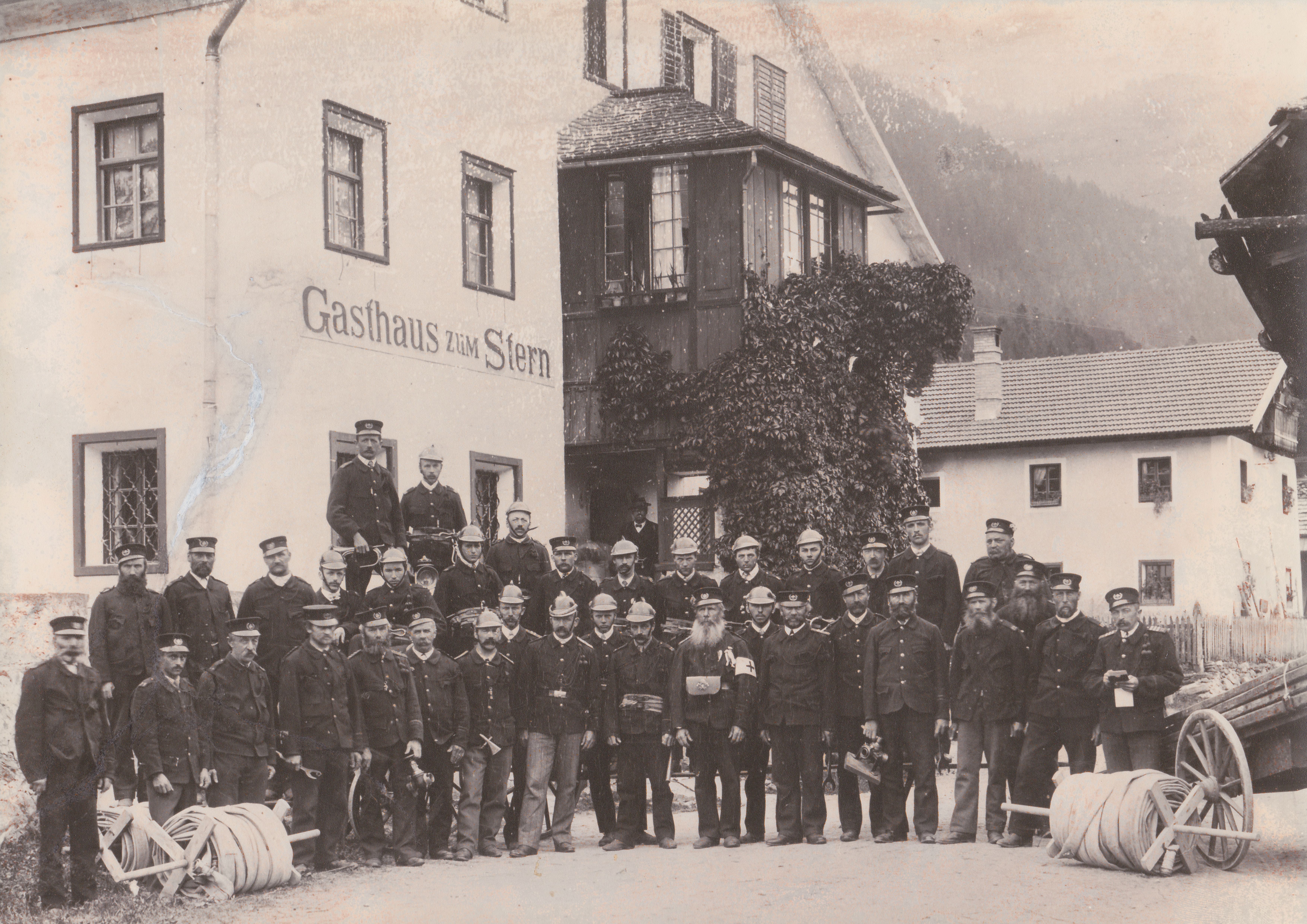 ein schwarz-weiß Foto der Feuerwehrmannschaft vor dem Gasthaus Stern