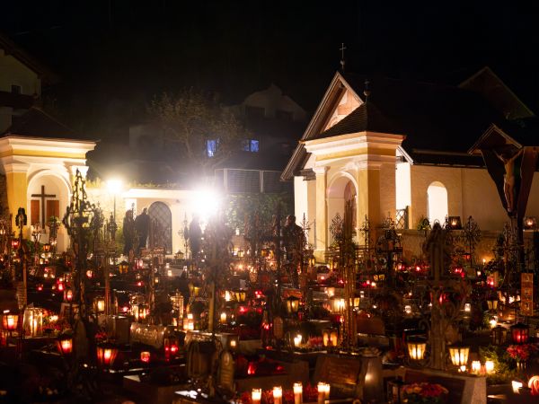 Ein nächtlich beleuchteter Friedhof mit zahlreichen Kerzen und der Aufbahrungshalle im Hintergrund.