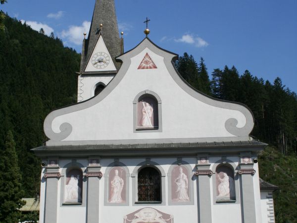 Die Pfarrkirche Hl. Bartholomäus aus der Frontansicht - im Vordergrund erkennbar die Friedhofsmauern mit dem Gatter dahinter die imposante Pfarrkirche..